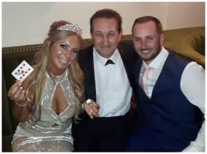 Trickster Andy Field with the bride and groom having just performed a card trick for them at their wedding in Gloucestershire
