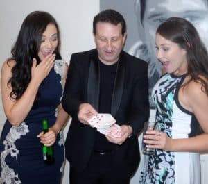 Two ladies reacting with surprise to a close up card trick at a wedding