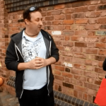 Street magician performing card trick on a busy street