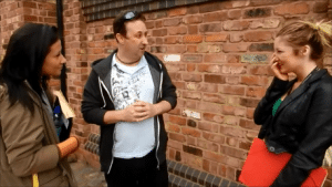 Street magician performing card trick on a busy street