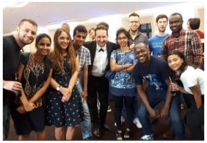 Andy Field Magician surrounded by teenagers after performing powerful close up magic