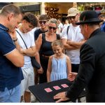 Swindon magician entertaining a crowd with close-up magic and misdirection during an outdoor performance.
