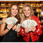 Two women holding money while discussing how much a magician costs in Oxford