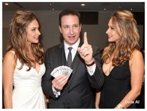 Magician performing close-up magic for two women