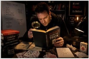 Magician reading a book to illustrate suggestion in magic