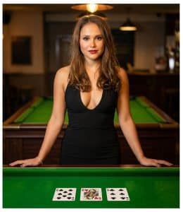 Woman holding three playing cards during a magic trick